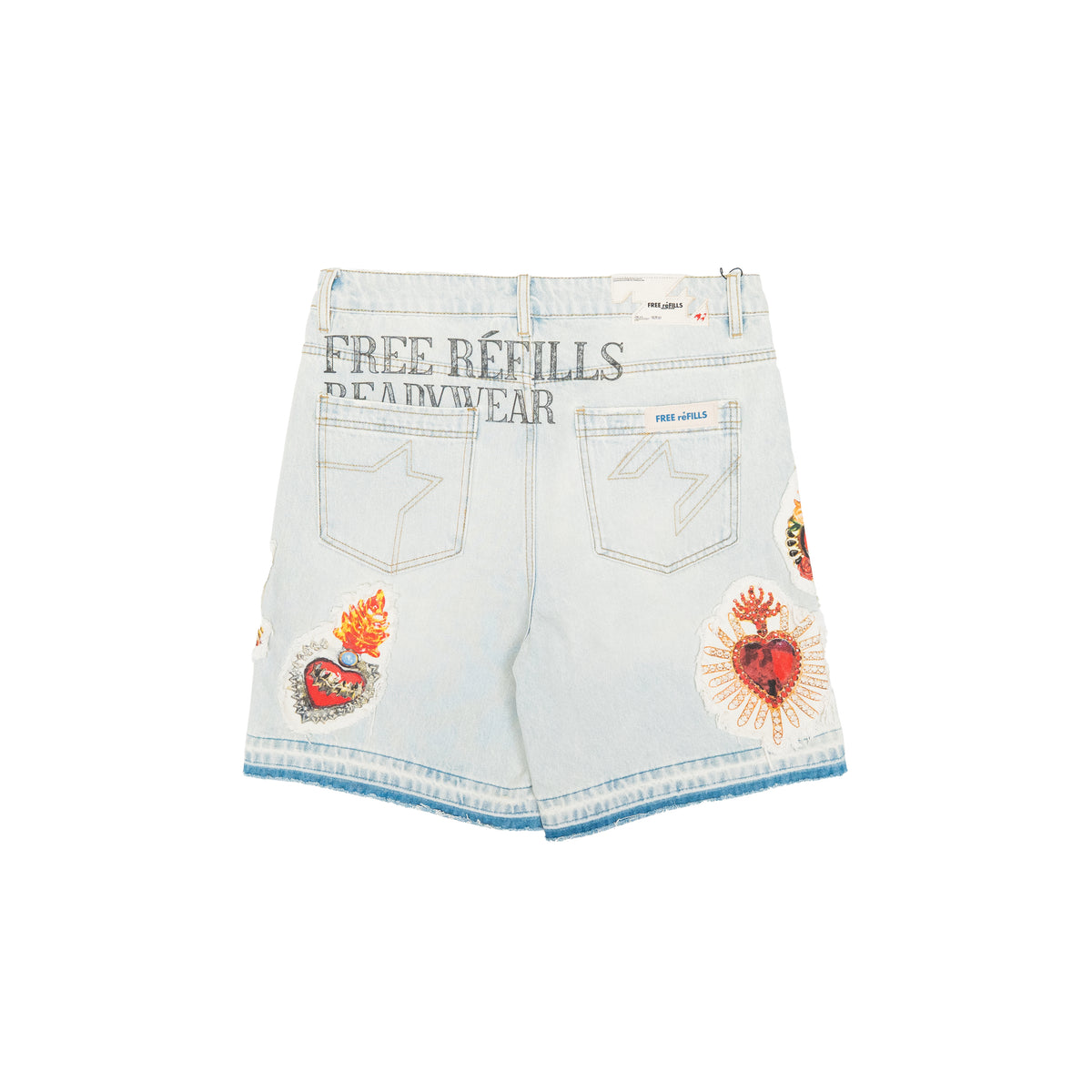 Light wash denim shorts with decorative patches, featuring 'FREE REFILLS READYWEAR' text on the back pocket area, shown against a plain white background.