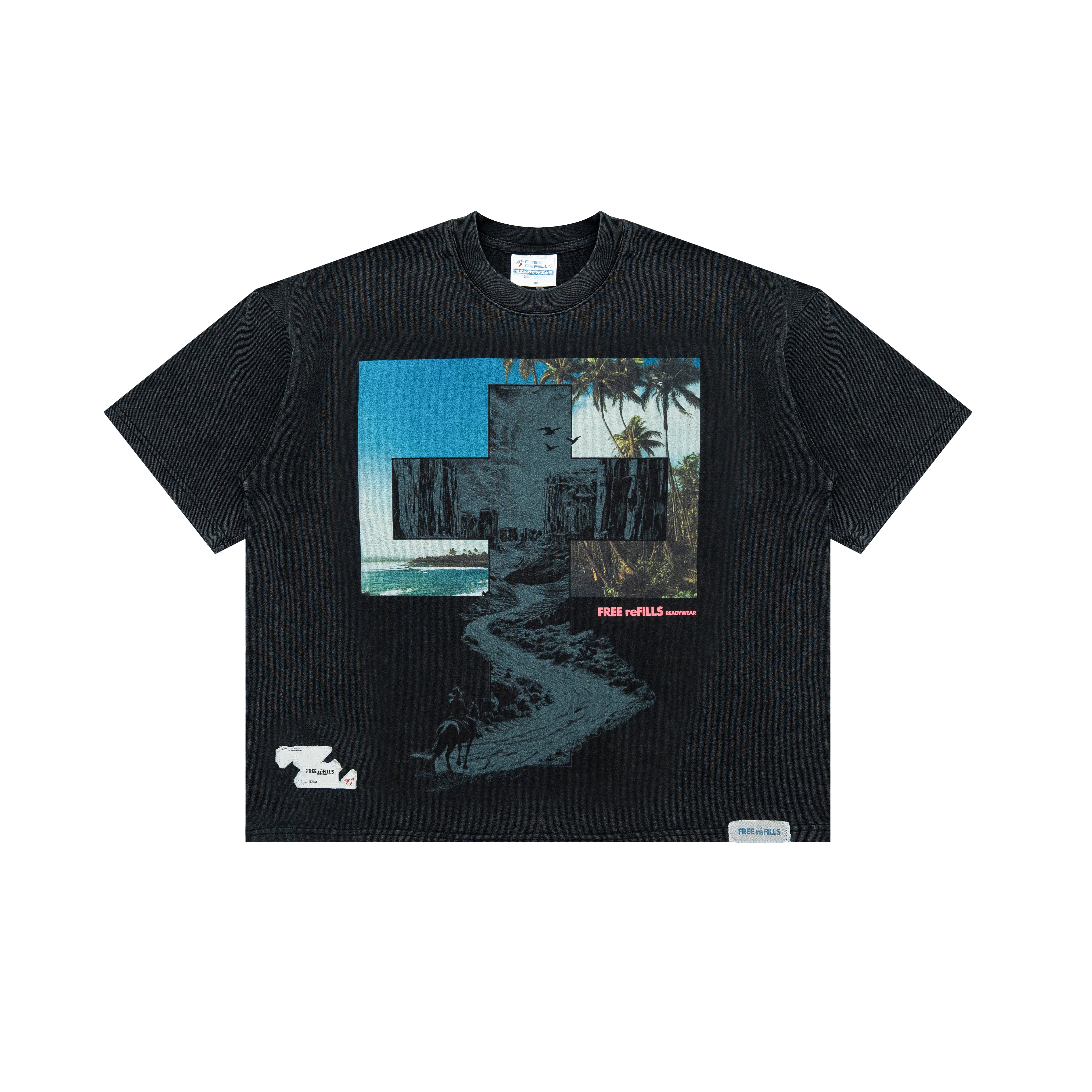 A black short-sleeve graphic t-shirt laid flat against a white background. The shirt features a large rectangular collage print on the chest with a blue sky, a beach path, and a building, alongside a small white graphic on the lower left and a small white brand label on the lower right hem.
