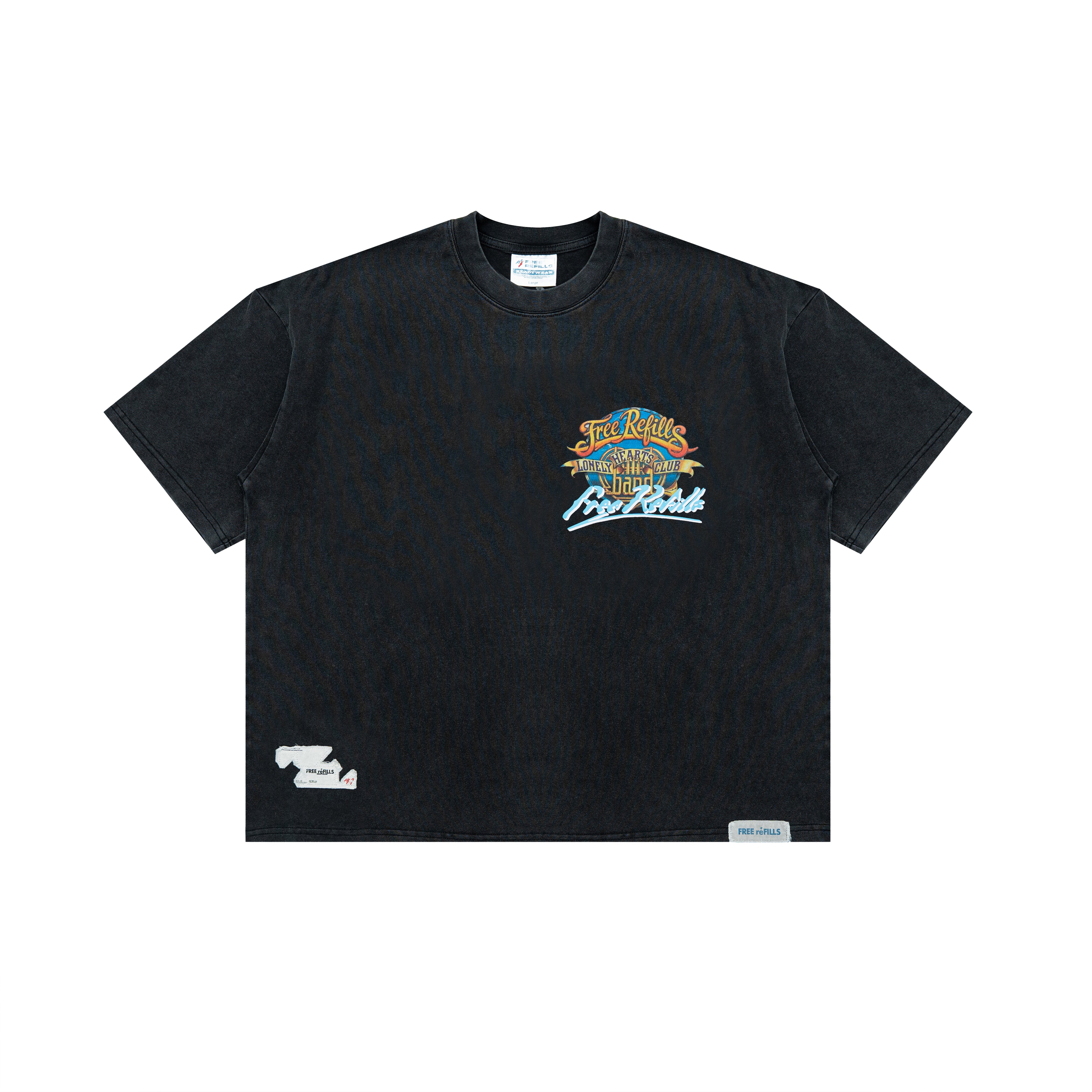 A black short-sleeve crewneck t-shirt with a colorful graphic on the left chest reading 'Lonely Hearts Club' and 'Free Refills' in blue, orange, and white. A small white graphic is printed on the lower left hem, and a small white brand tag is visible on the right hem.