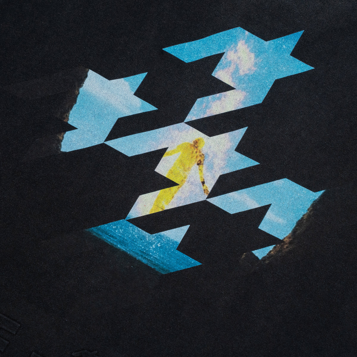 A square graphic print or artwork on a dark textured background, featuring a central yellow figure walking through a geometric pattern of blue star-like shapes with sky and cloud imagery.