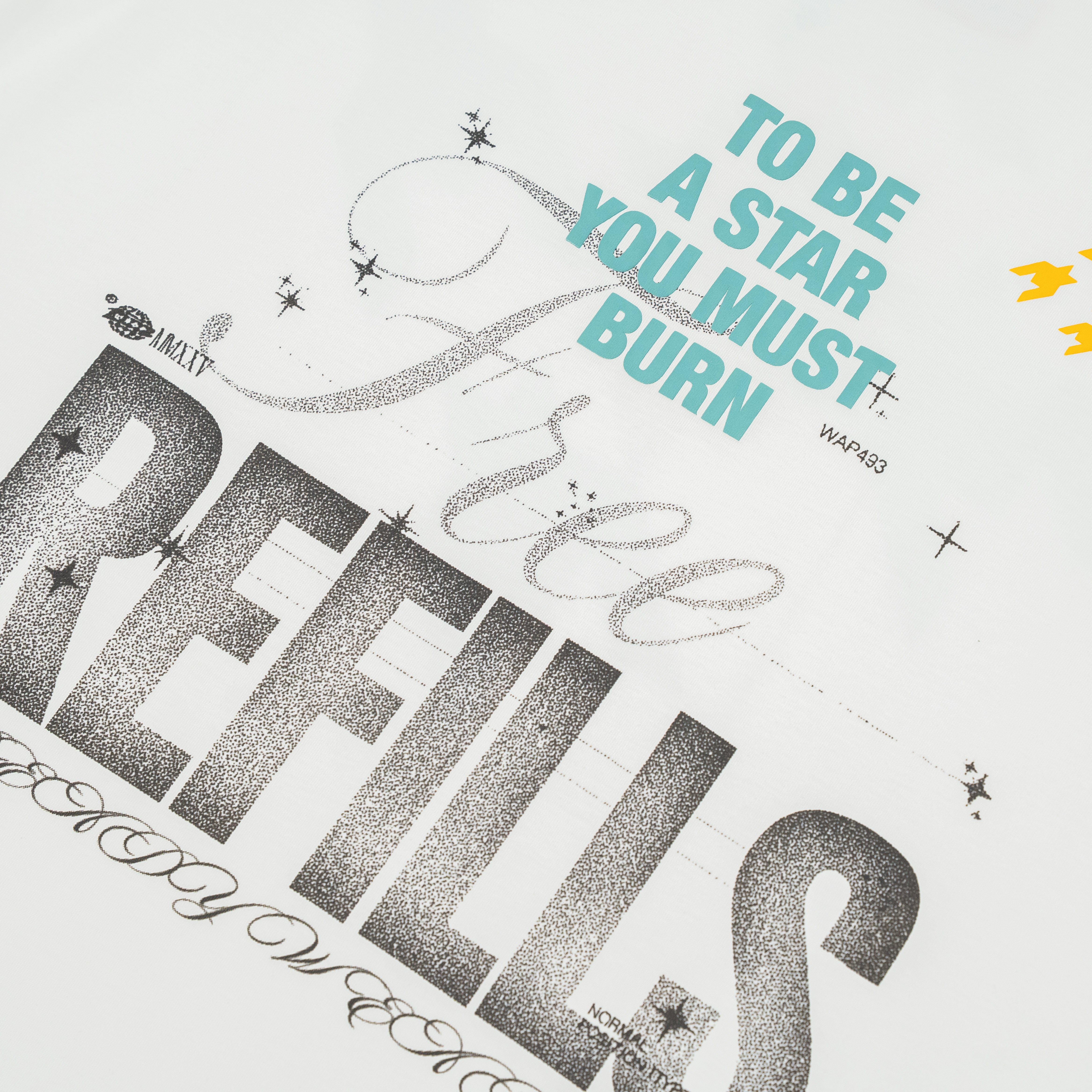 A close-up of a white graphic print featuring the phrase 'TO BE A STAR YOU MUST BURN' in light blue and large textured black lettering that reads 'FREE REFILLS.' Decorative script and small star accents are also visible.