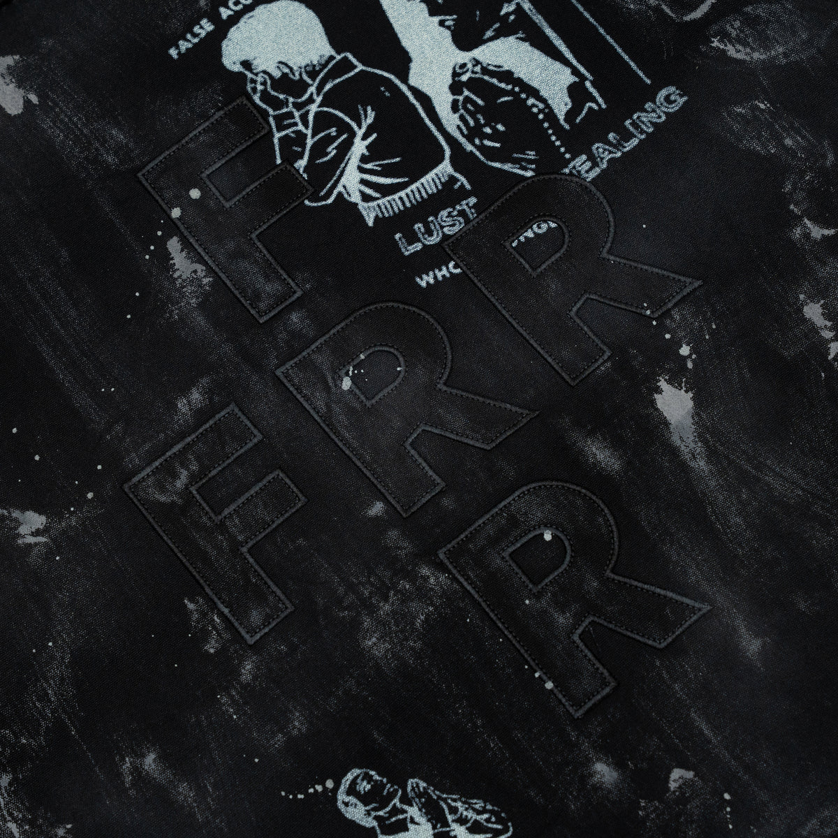 Miracle Jacket – Black – Close-up of tonal FRR back lettering, pale illustrations, and gray mottled fabric.