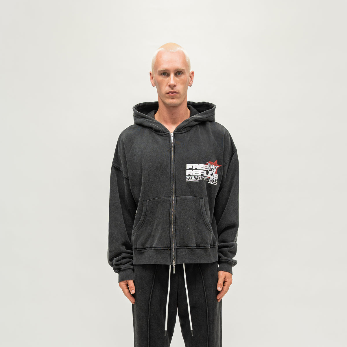 Sunday Service Hoodie – Black – Front view on model showing zip closure, chest graphic and split kangaroo pocket