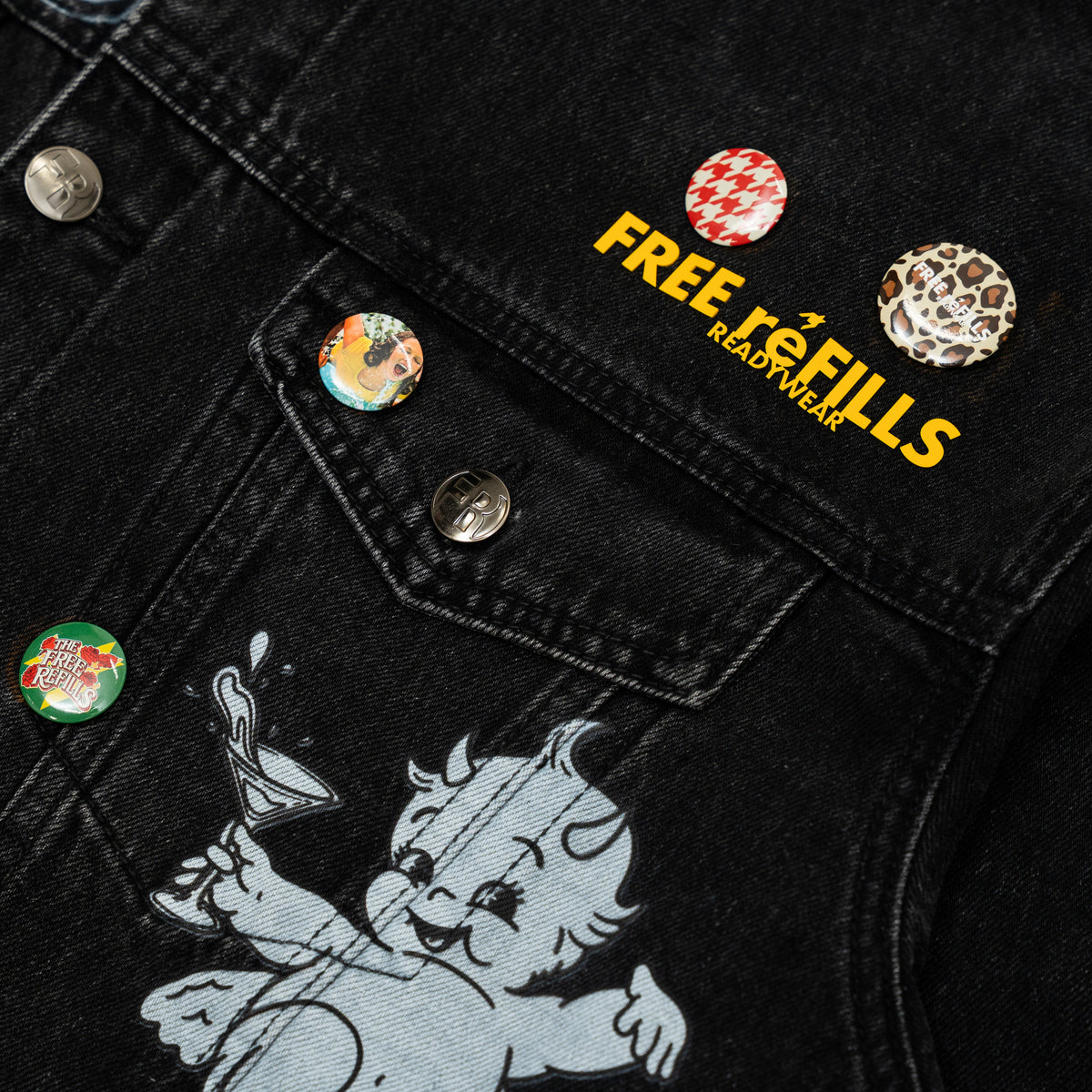 The Powder Room Jacket – Black – Close-up of chest pocket, decorative pins and cherub graphic
