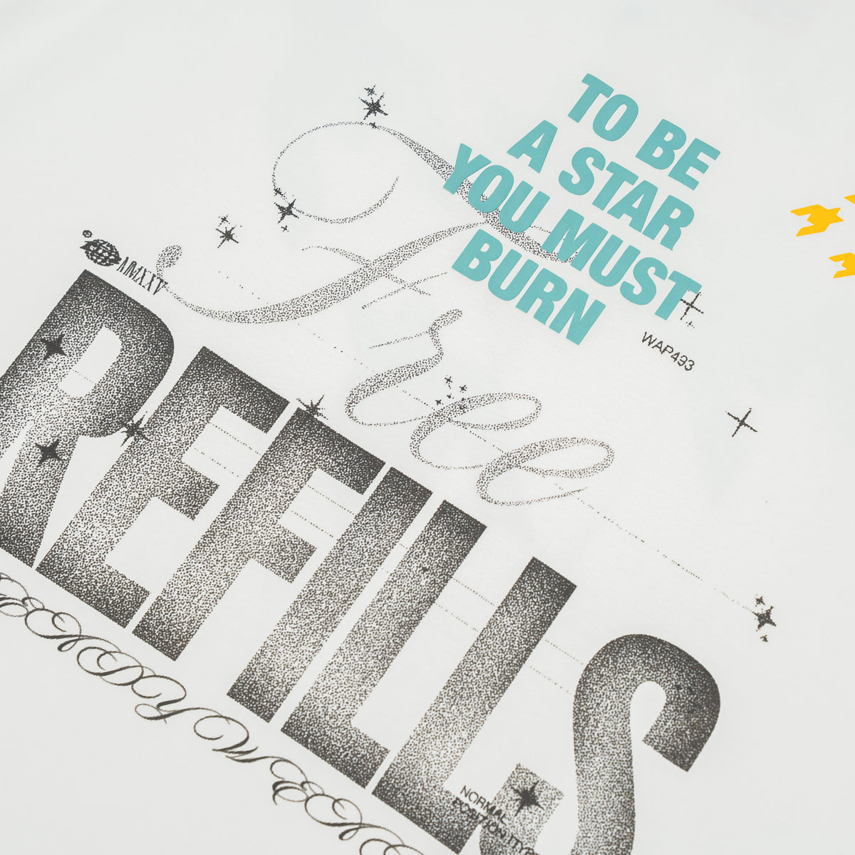 A close-up of a white graphic print featuring the phrase 'TO BE A STAR YOU MUST BURN' in light blue and large textured black lettering that reads 'FREE REFILLS.' Decorative script and small star accents are also visible.