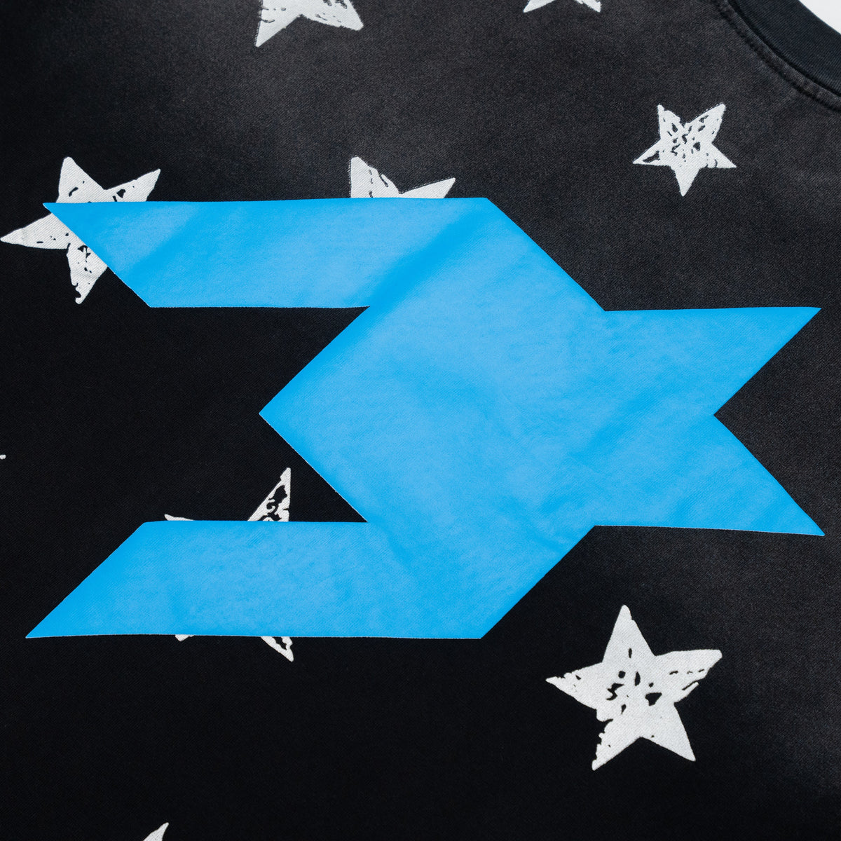 Close-up of a black graphic T-shirt featuring a large bright blue chevron-like logo and scattered distressed white stars.