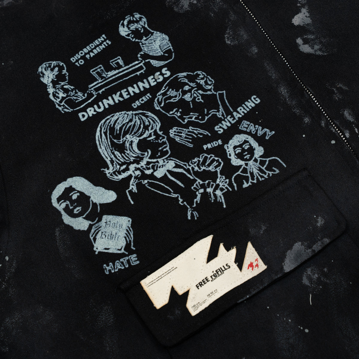 Miracle Jacket – Black – Close-up of front illustrations and cream FREE ReFILLS patch on the flap pocket.
