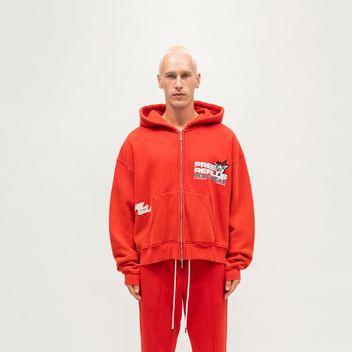 Sunday Service Hoodie – Red – Front view on model showing zip closure, chest graphic and split kangaroo pocket