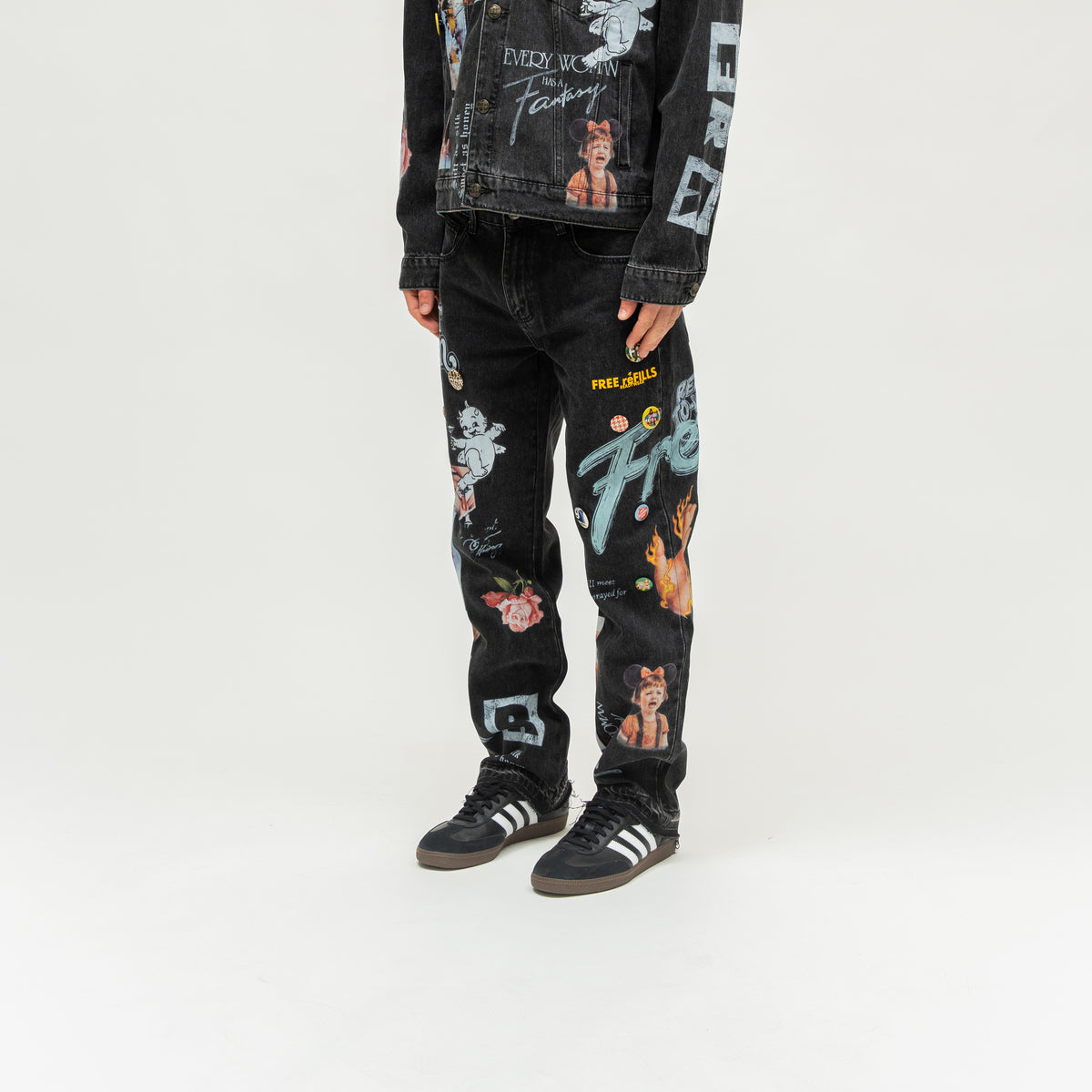 The Powder Room Jeans – Black – Angled view on model showing oversized lettering and colorful leg graphics