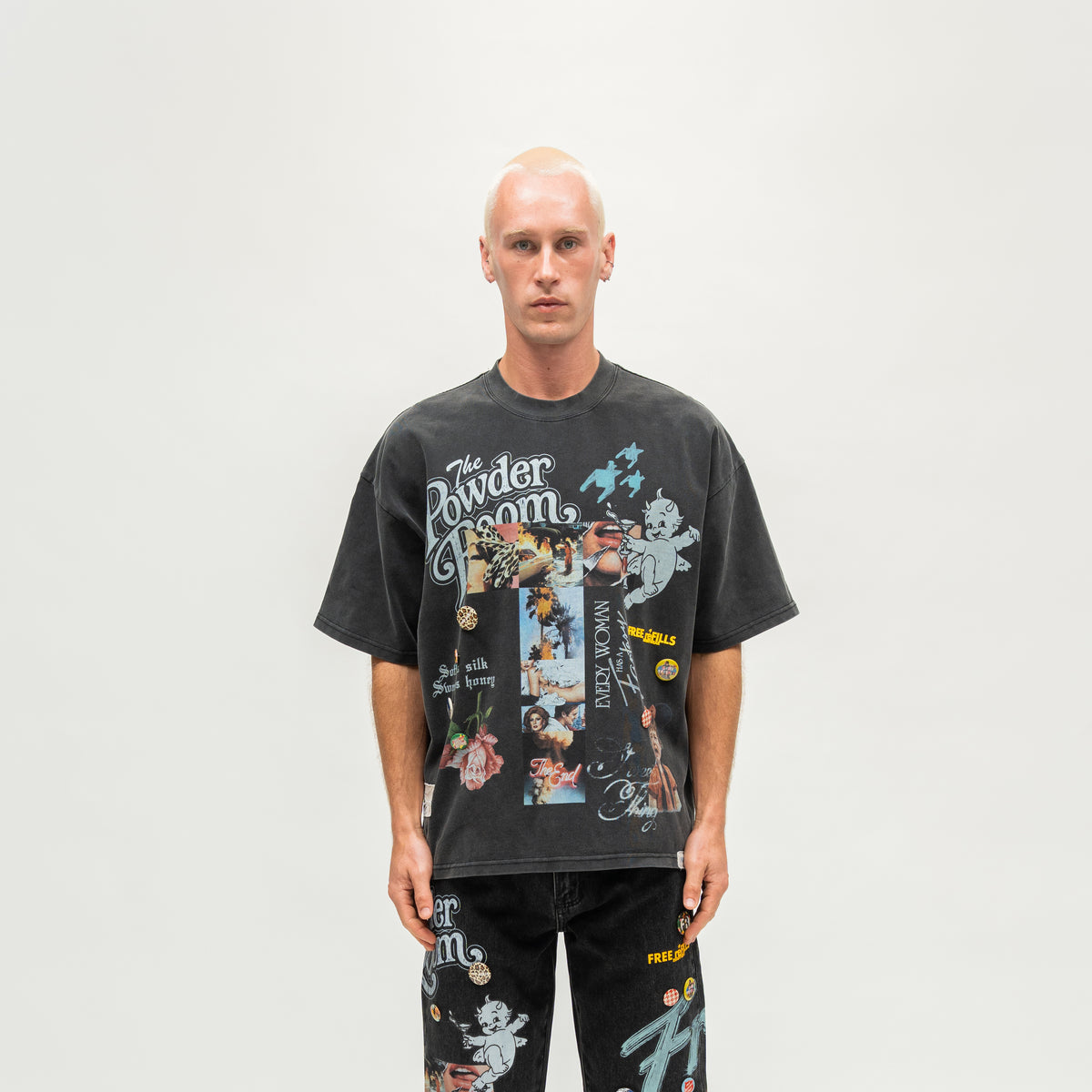The Powder Room Tee – Black – Front view on model showing collage graphics and decorative pins
